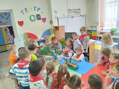 Наставники и дети сравнивают у кого выше выросли перья лука