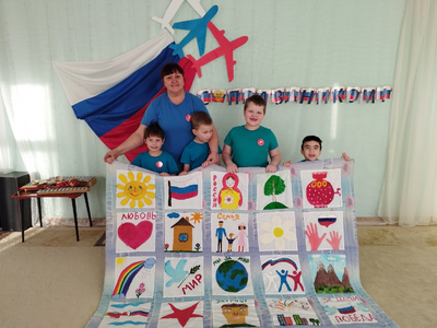 Педагог и дети демонстрируют "Лоскутное одеяло Победы"